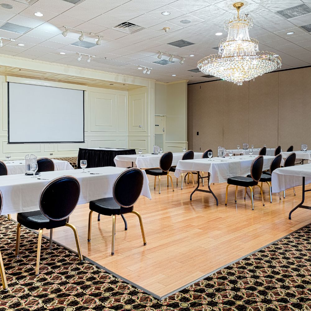 Conference room with round tables, black chairs, and a chandelier