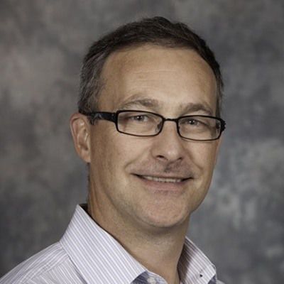 Smiling man in glasses wearing a light shirt