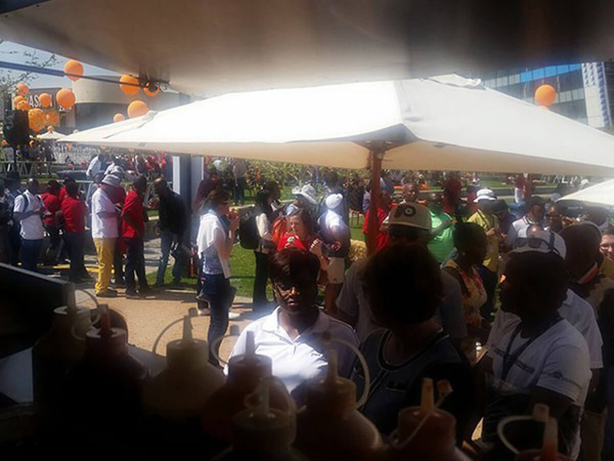 Crowd at a coffee bar event with shaded umbrellas
