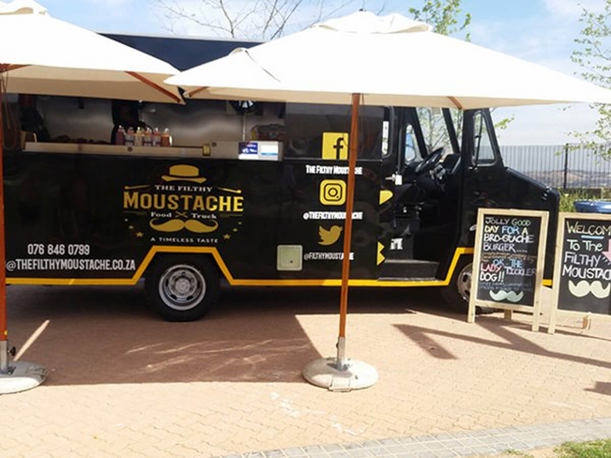 Coffee truck with umbrellas and signage