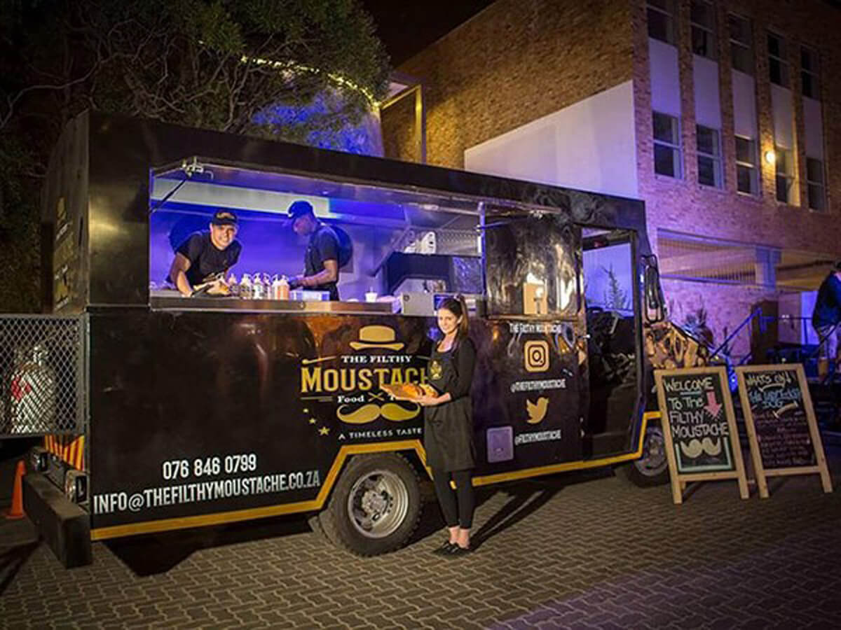 Coffee truck with staff preparing food at night.