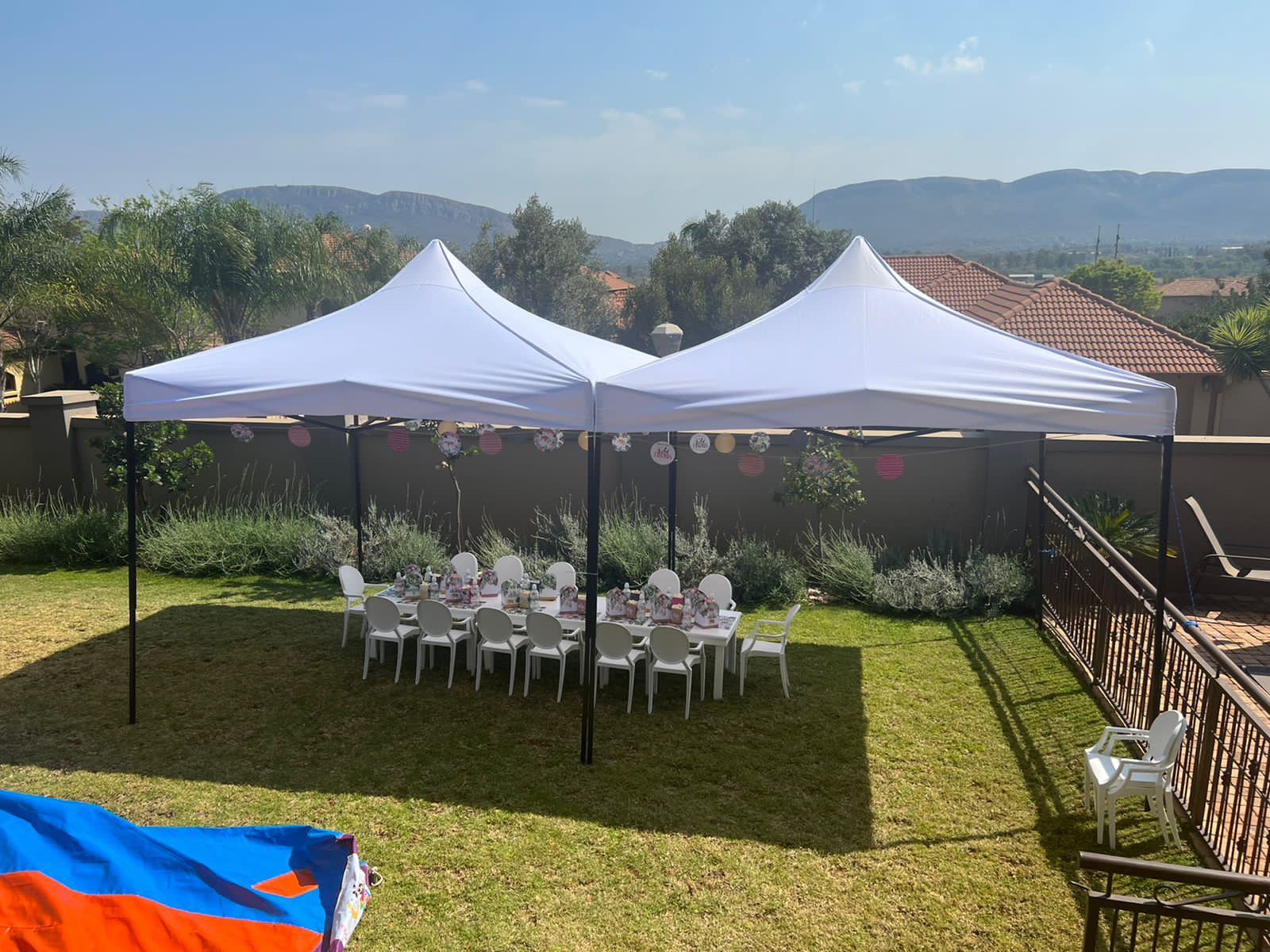 Two white gazebos set up in a garden for an outdoor event