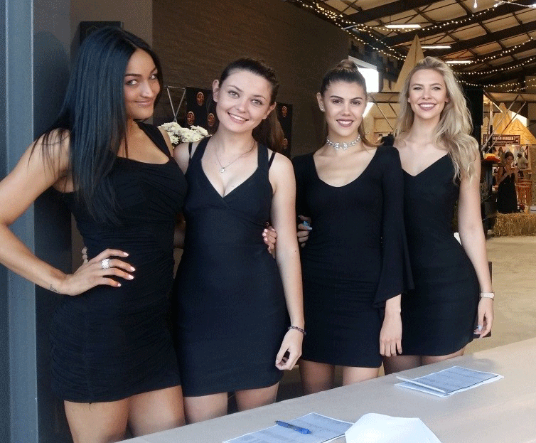 Four baristas in black dresses posing together.
