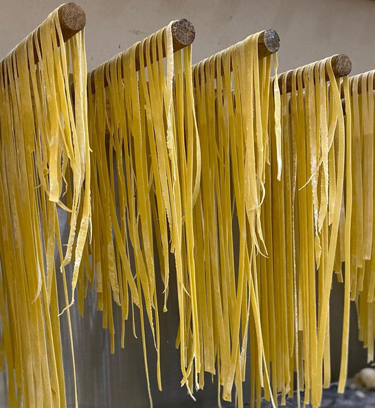 Hanging strips of freshly made yellow pasta