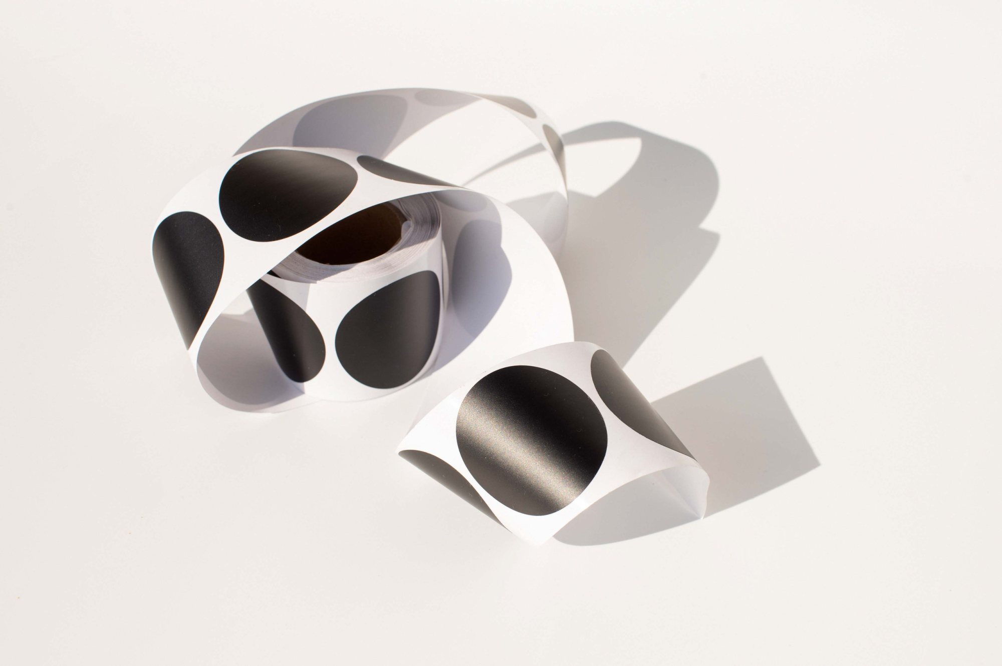 Roll of black and white custom stickers with circular designs