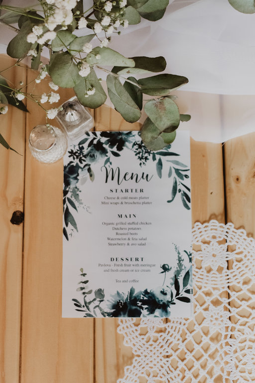 Beautifully designed menu with floral accents on wooden table
