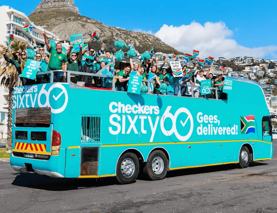 Open-top party bus with people celebrating and holding signs