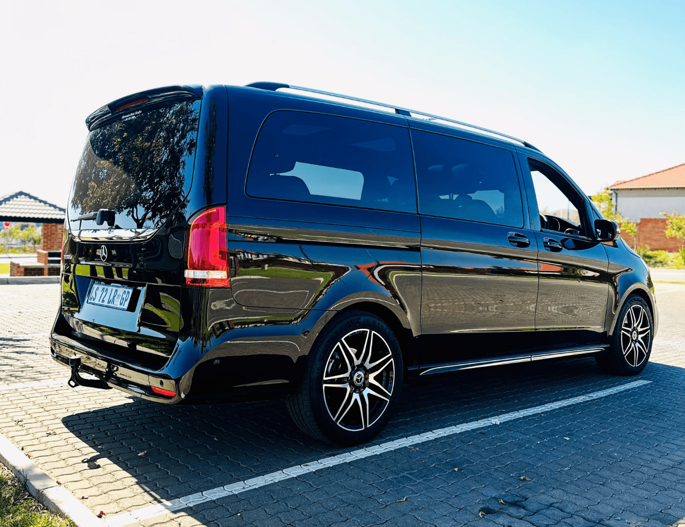 Black luxury shuttle van parked on a driveway.
