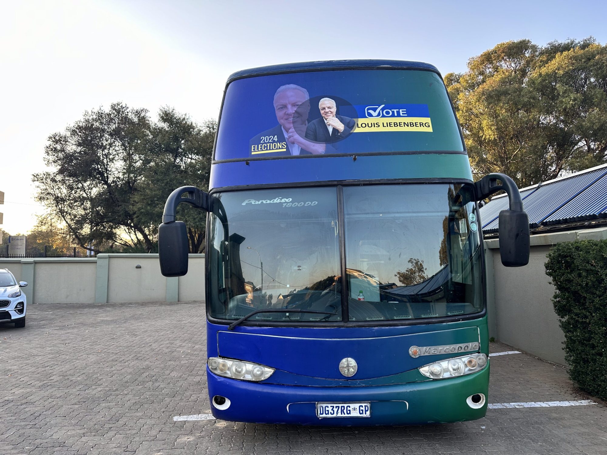Blue and green party bus with promotional graphics
