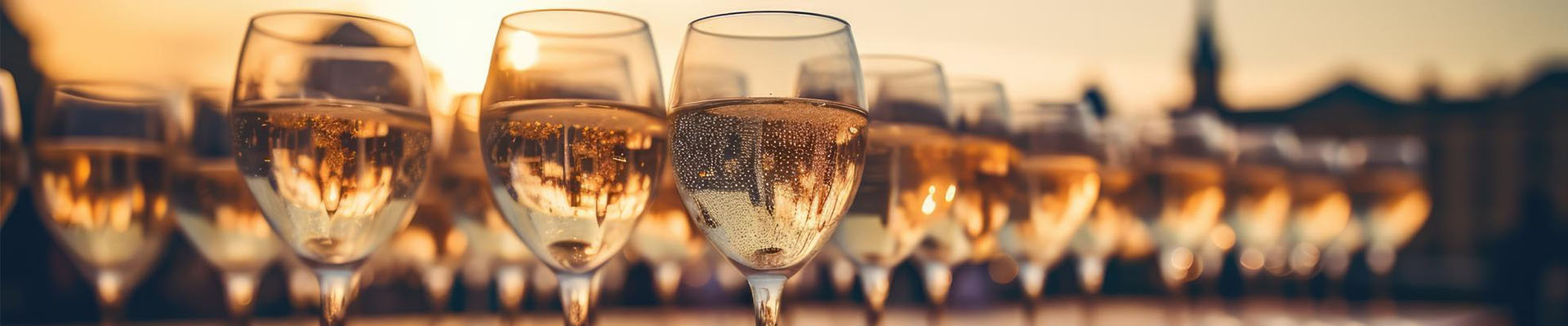 Row of glasses filled with white wine at sunset