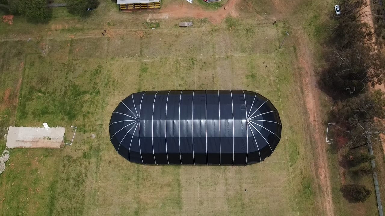 Aerial view of a large black marquee on grass