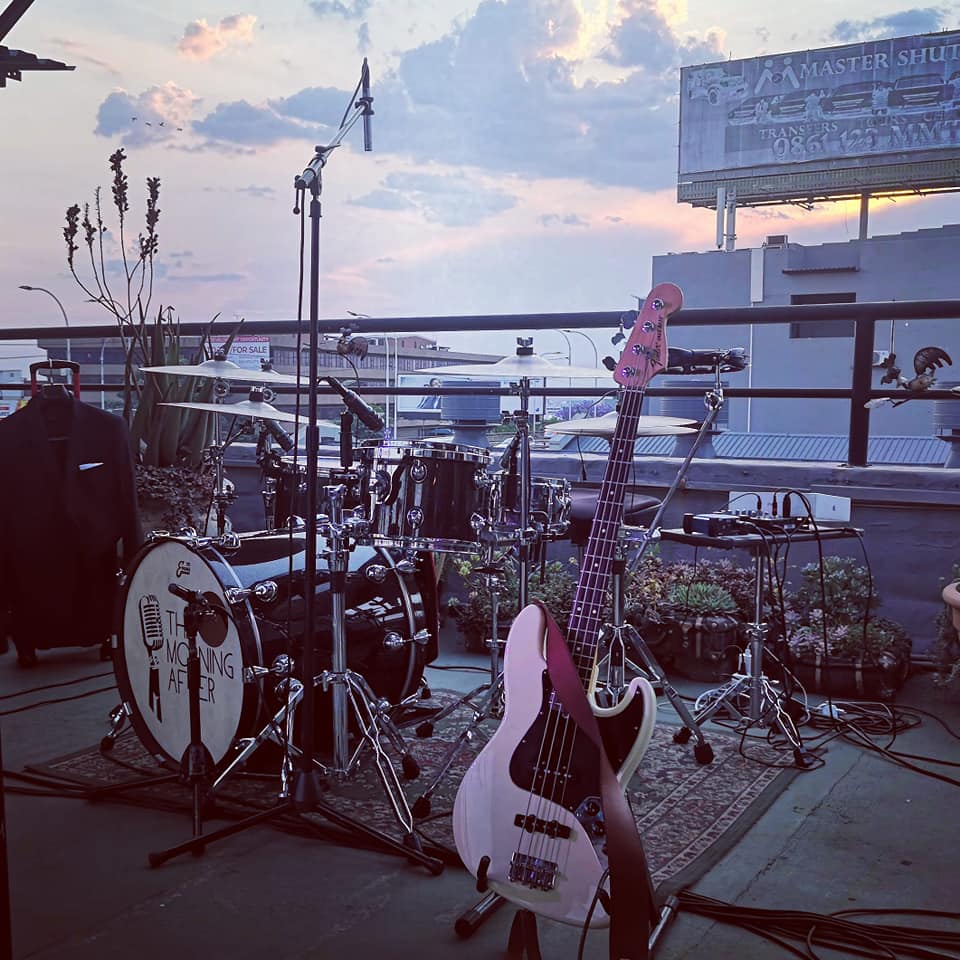 Stage setup with drums, bass guitar, and microphone.