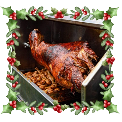 Whole lamb on a spit roasting with decorative holly