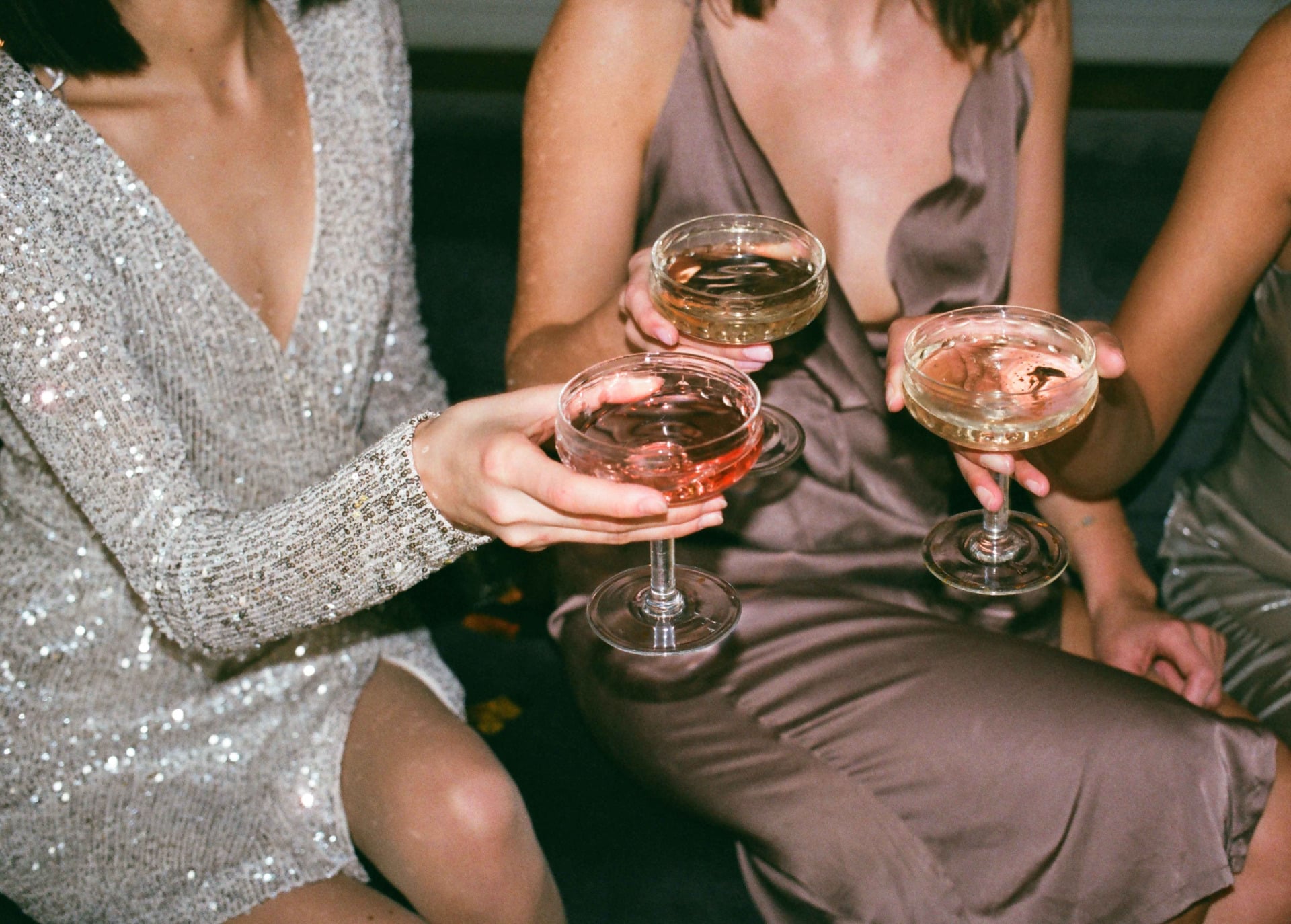 Three guests toasting with champagne coupes.