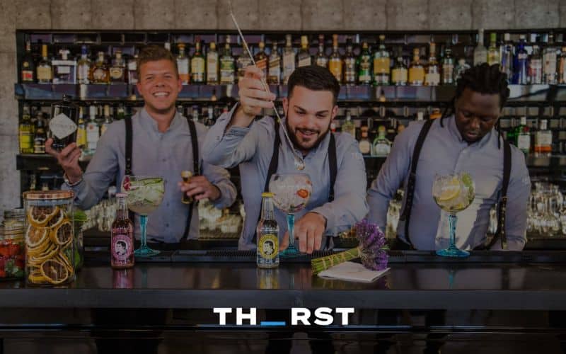 Three bartenders preparing cocktails at a mobile bar