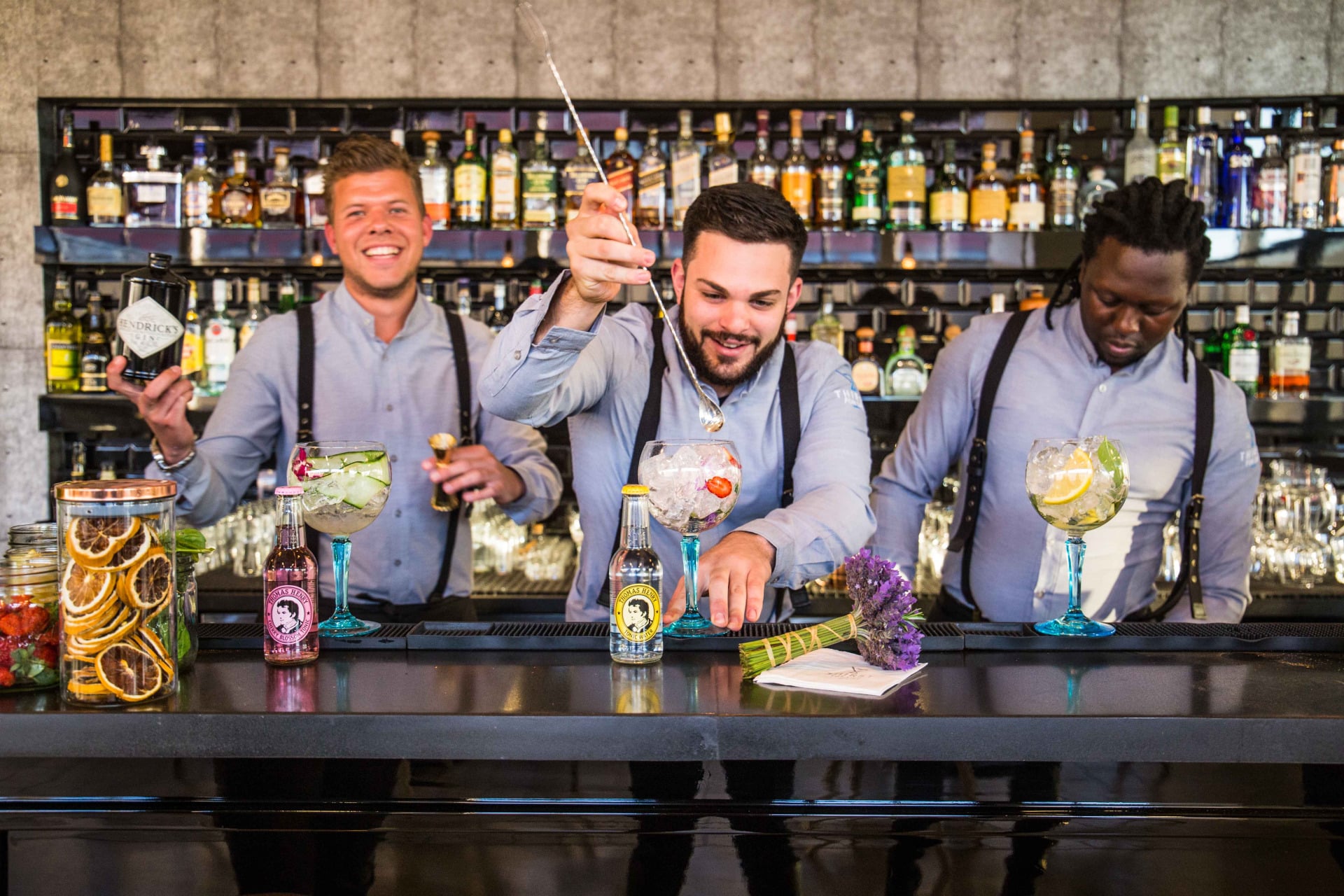 Three bartenders making cocktails at a mobile bar