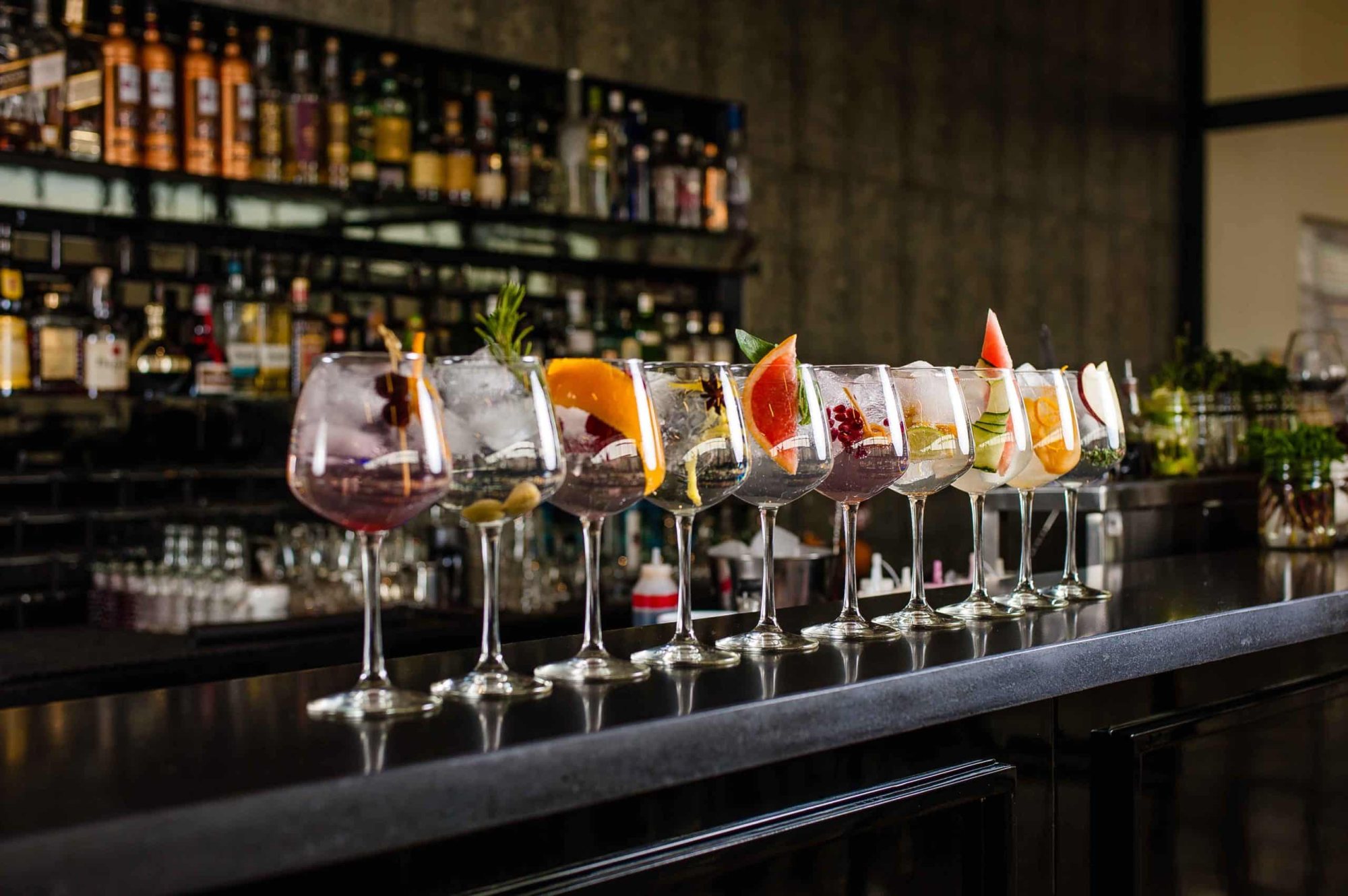 Row of colorful cocktails on a bar counter