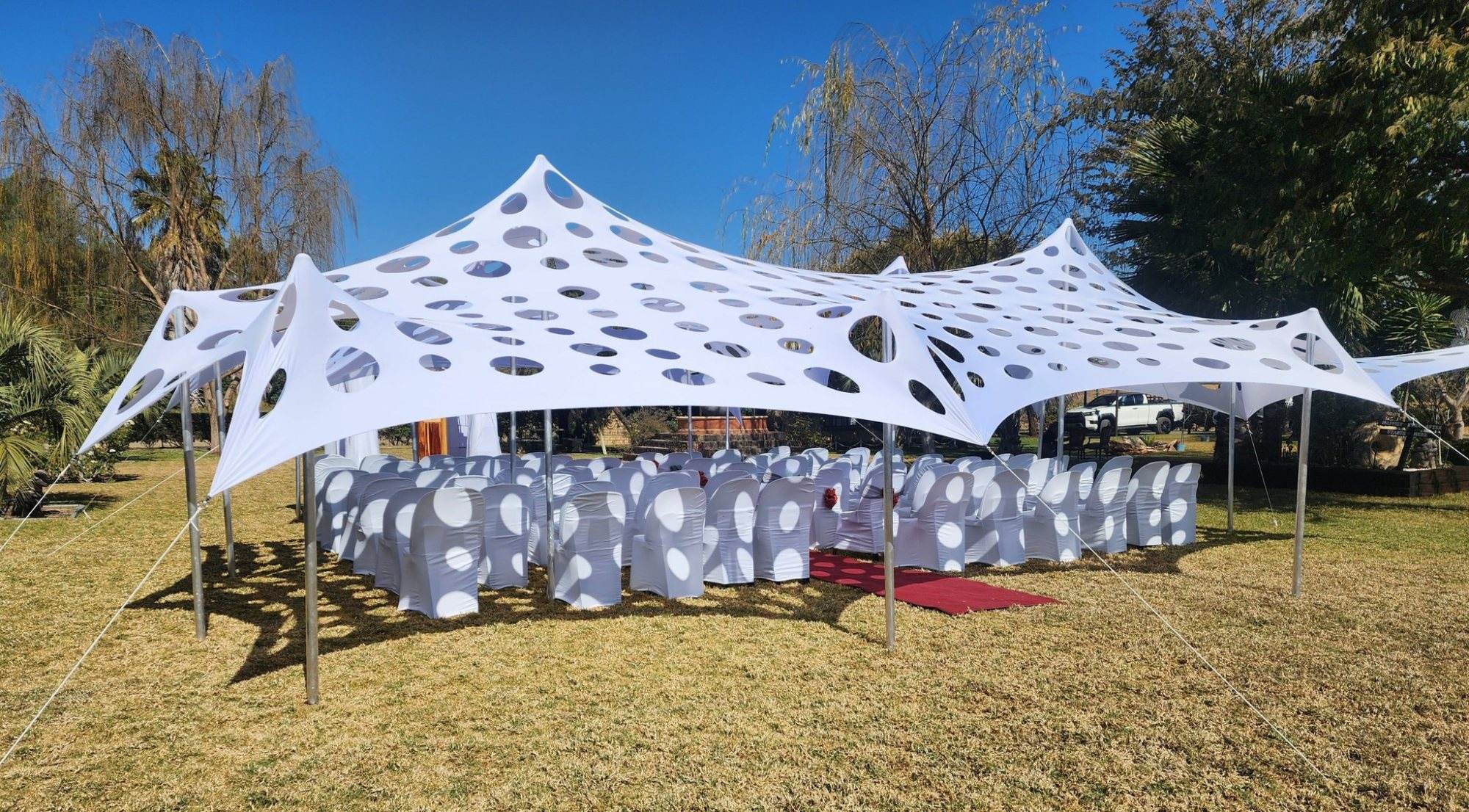 White canopy tent over chairs for an outdoor wedding.