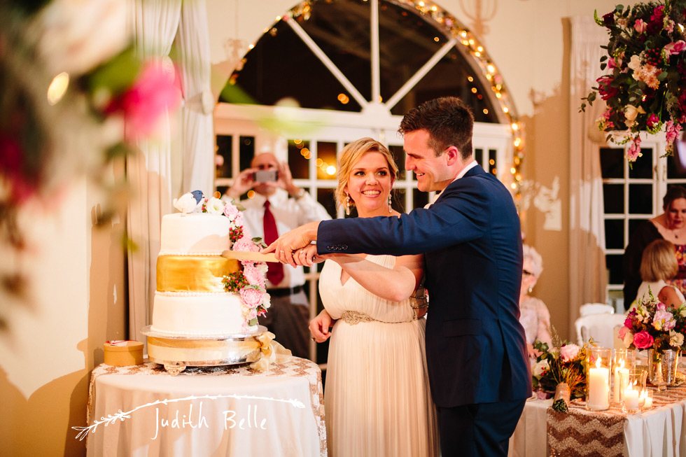 Bride and groom cutting wedding cake at reception