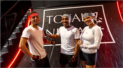 Three staff members from Total Ninja posing at the venue