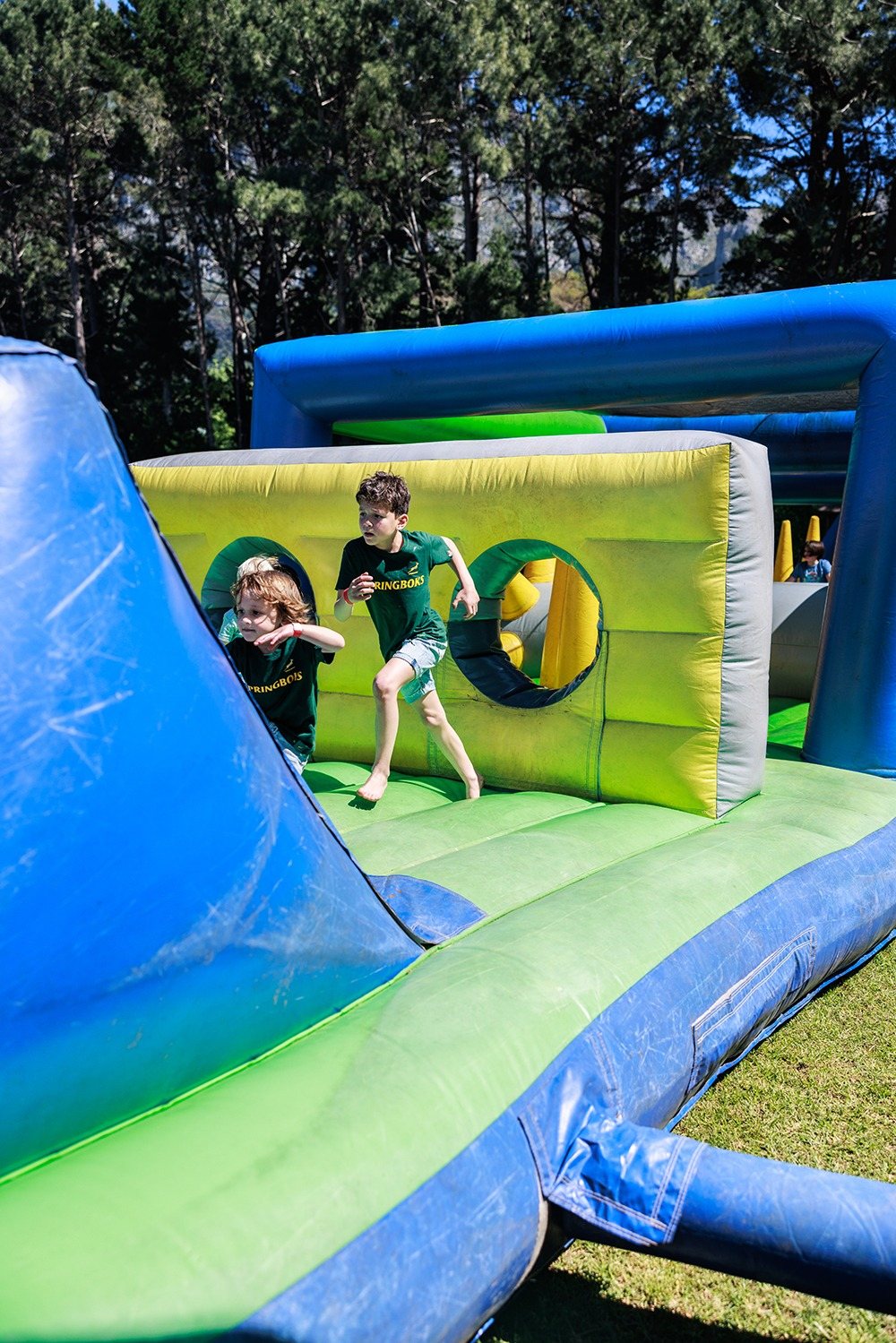 Children running through a colorful inflatable obstacle course