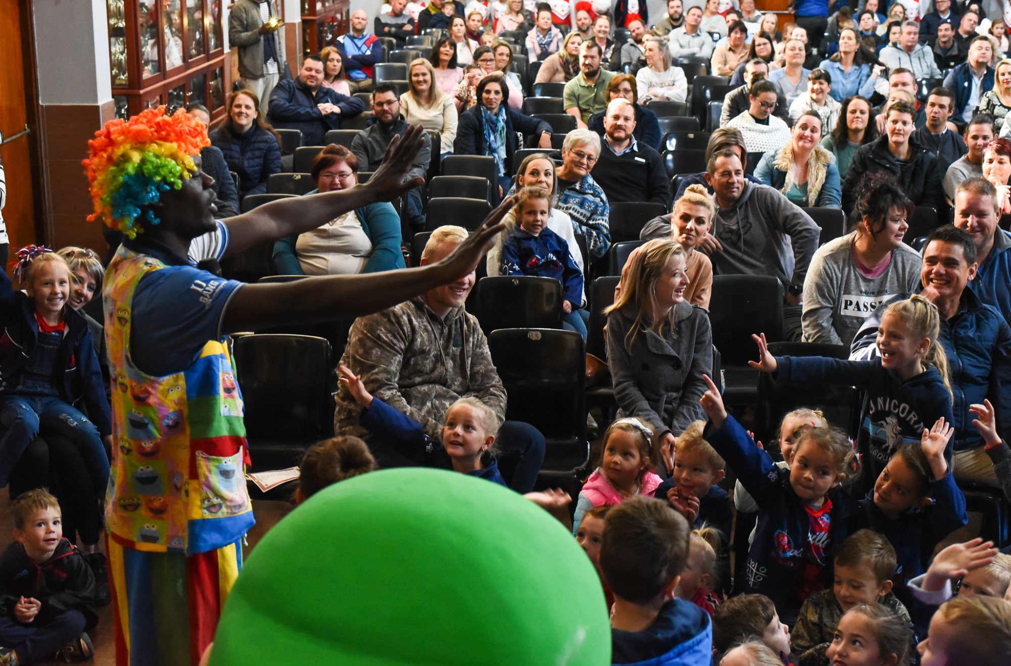 Audience enjoying a live performance with children and adults watching attentively.