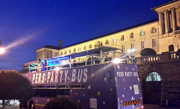 Pers Party Bus parked at a venue with lights on