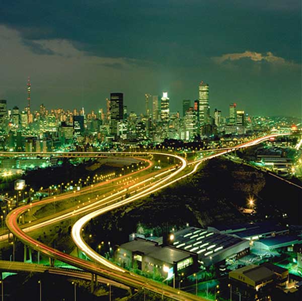Night view of a city skyline with illuminated highways.