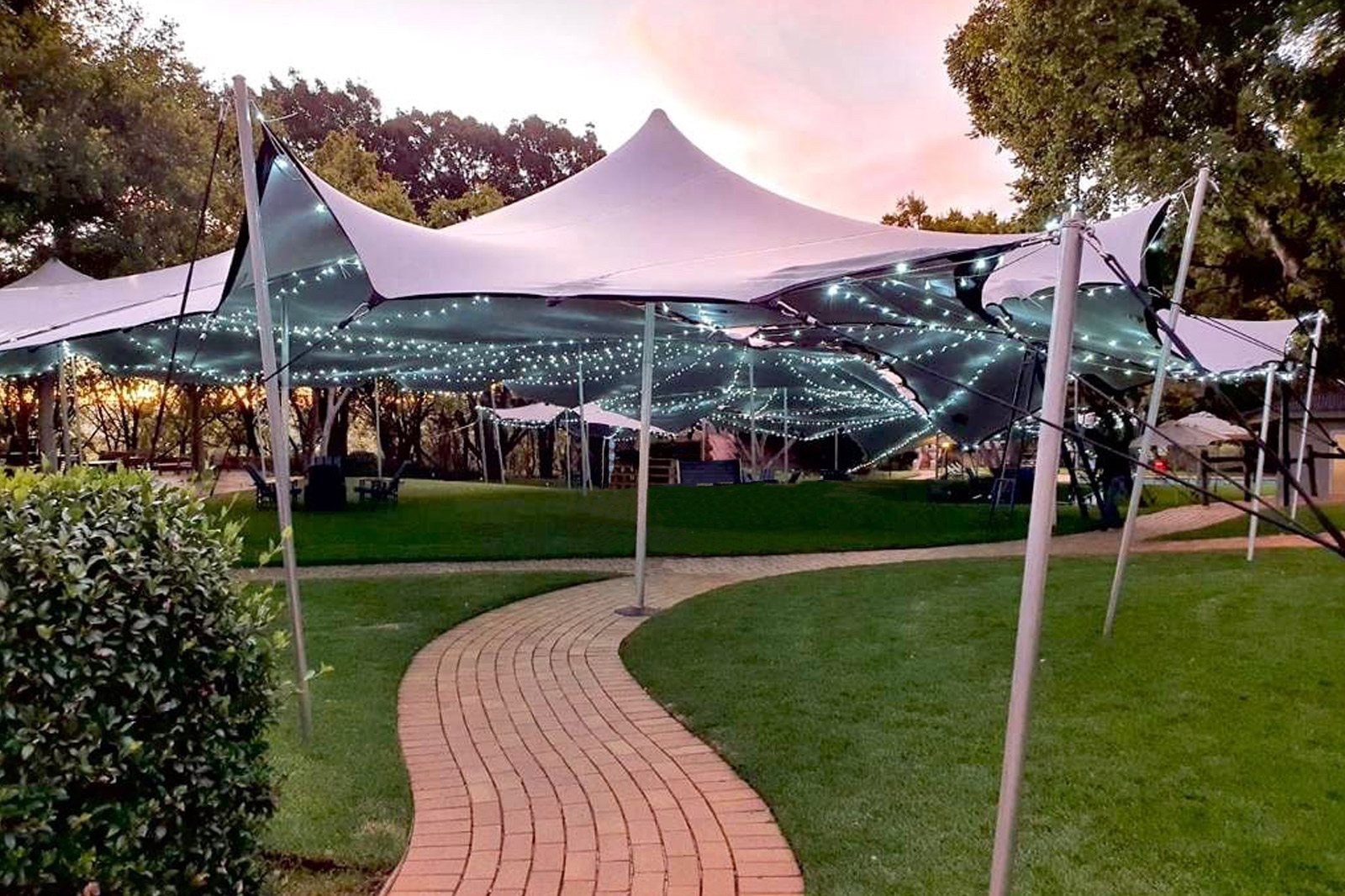 Large outdoor gazebo with string lights set up in a garden