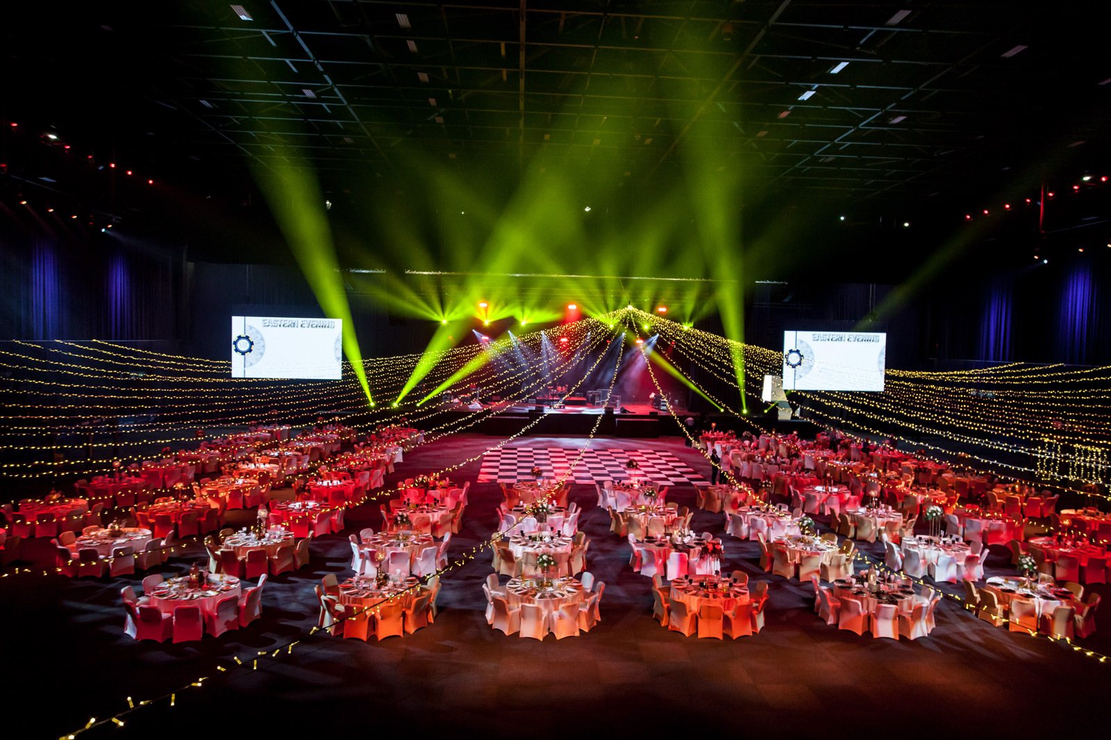 Large event space set up with tables and decorative lighting