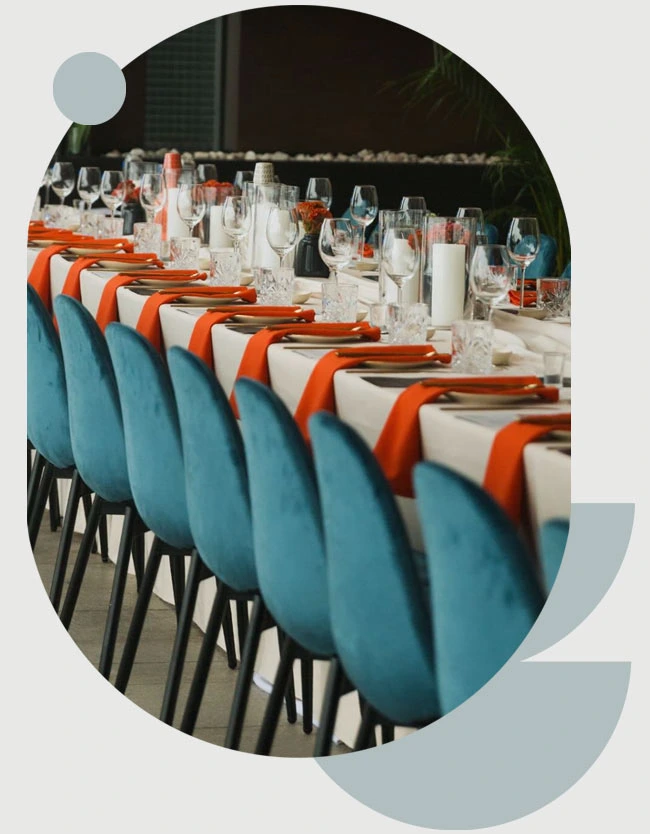 Stylish blue chairs with orange napkins on a dining table