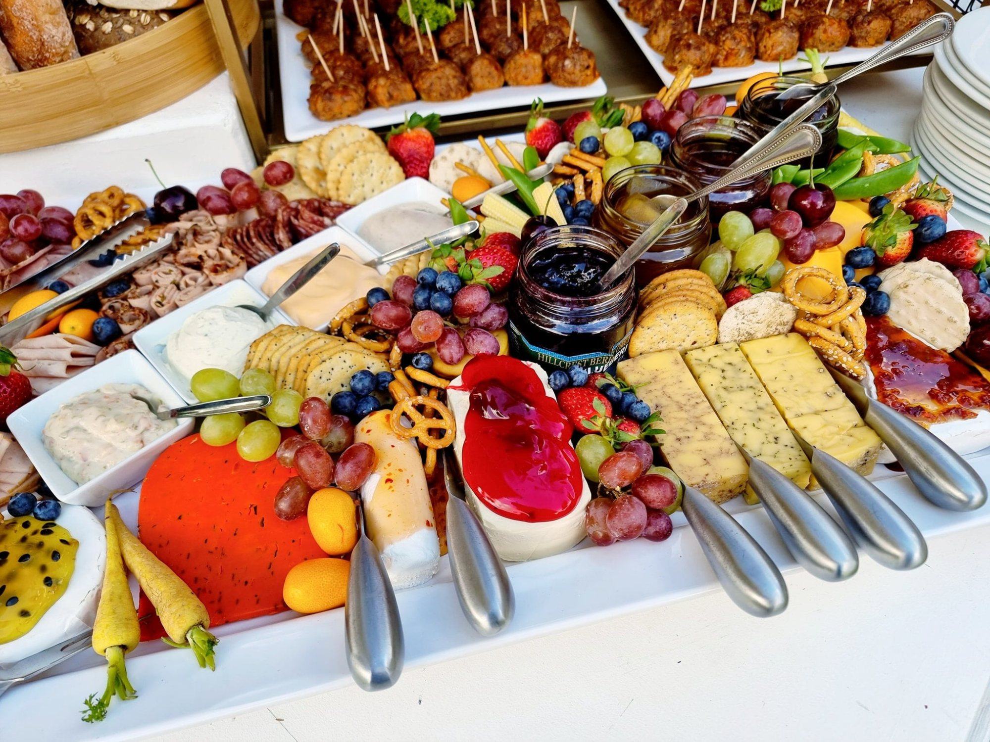 Catering platter with cheeses, fruits, and dips