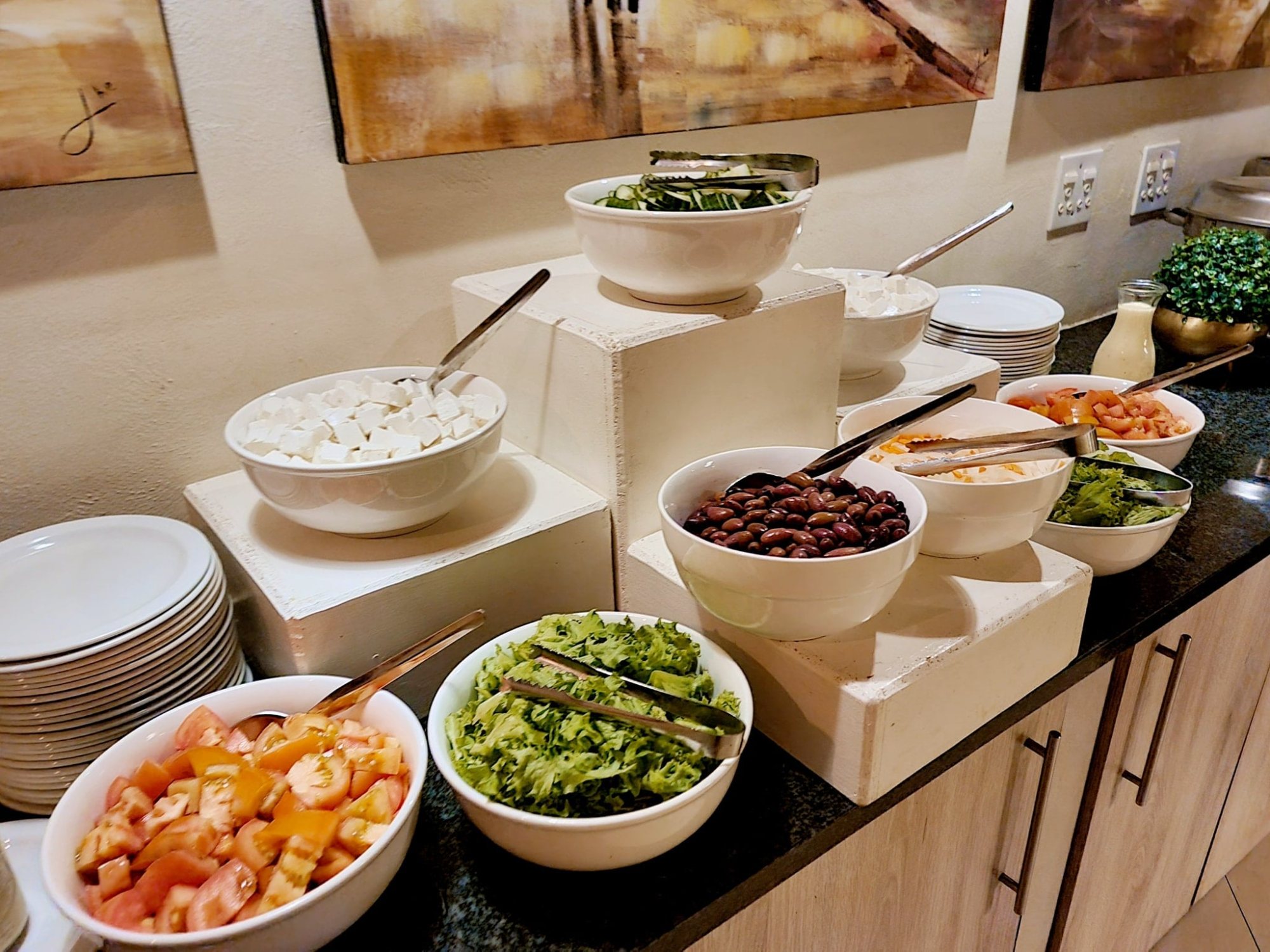 Salad and toppings displayed in bowls on a countertop.