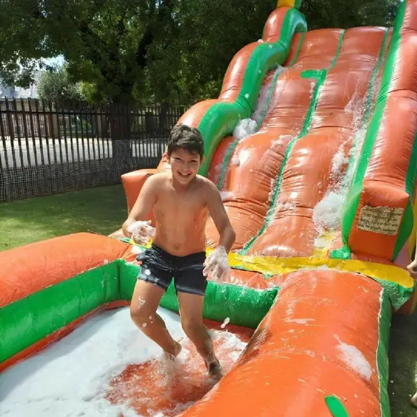Boy playing on an inflatable water slide