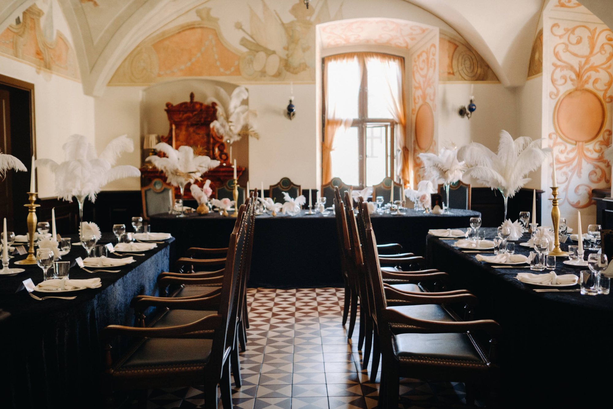 Elegant dining setup with black linens and feather centrepieces
