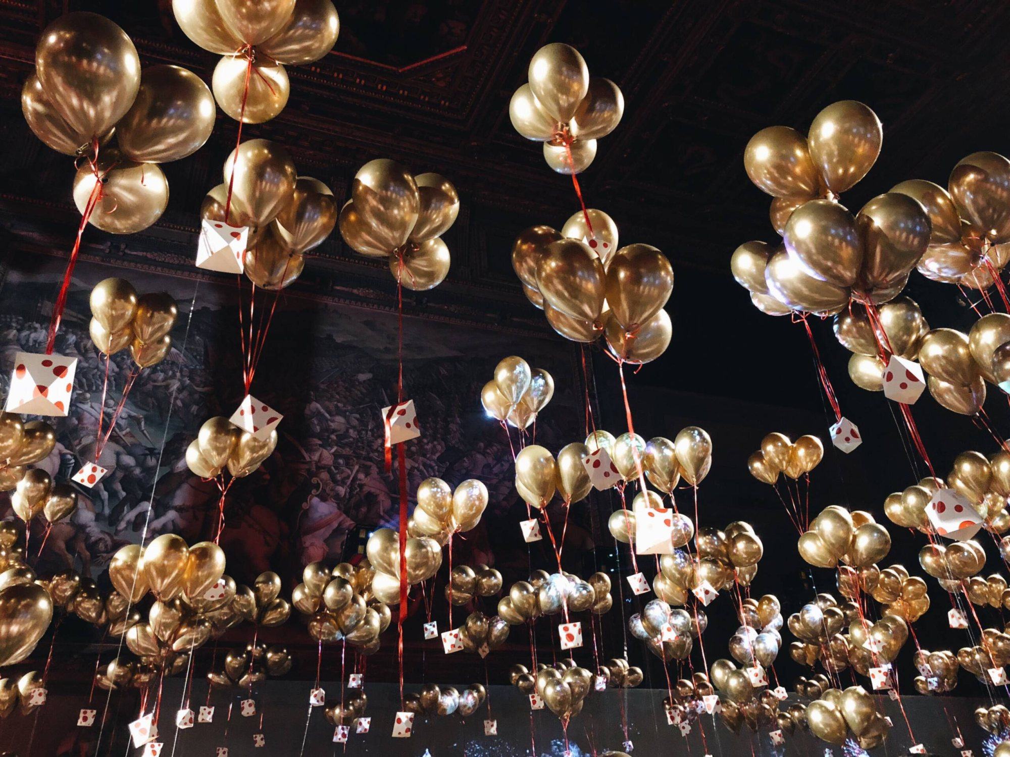A ceiling adorned with gold heart-shaped balloons and hanging decorations.