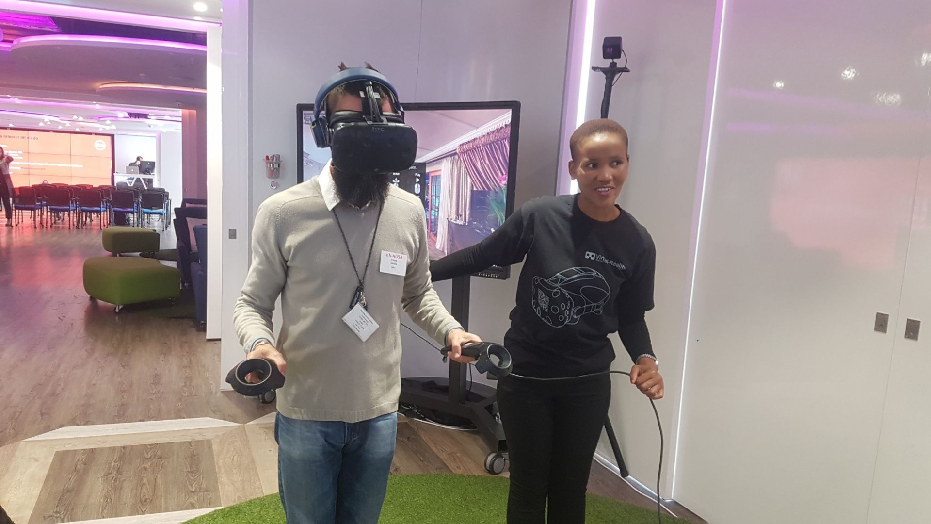 Man using VR headset while woman assists in setup.