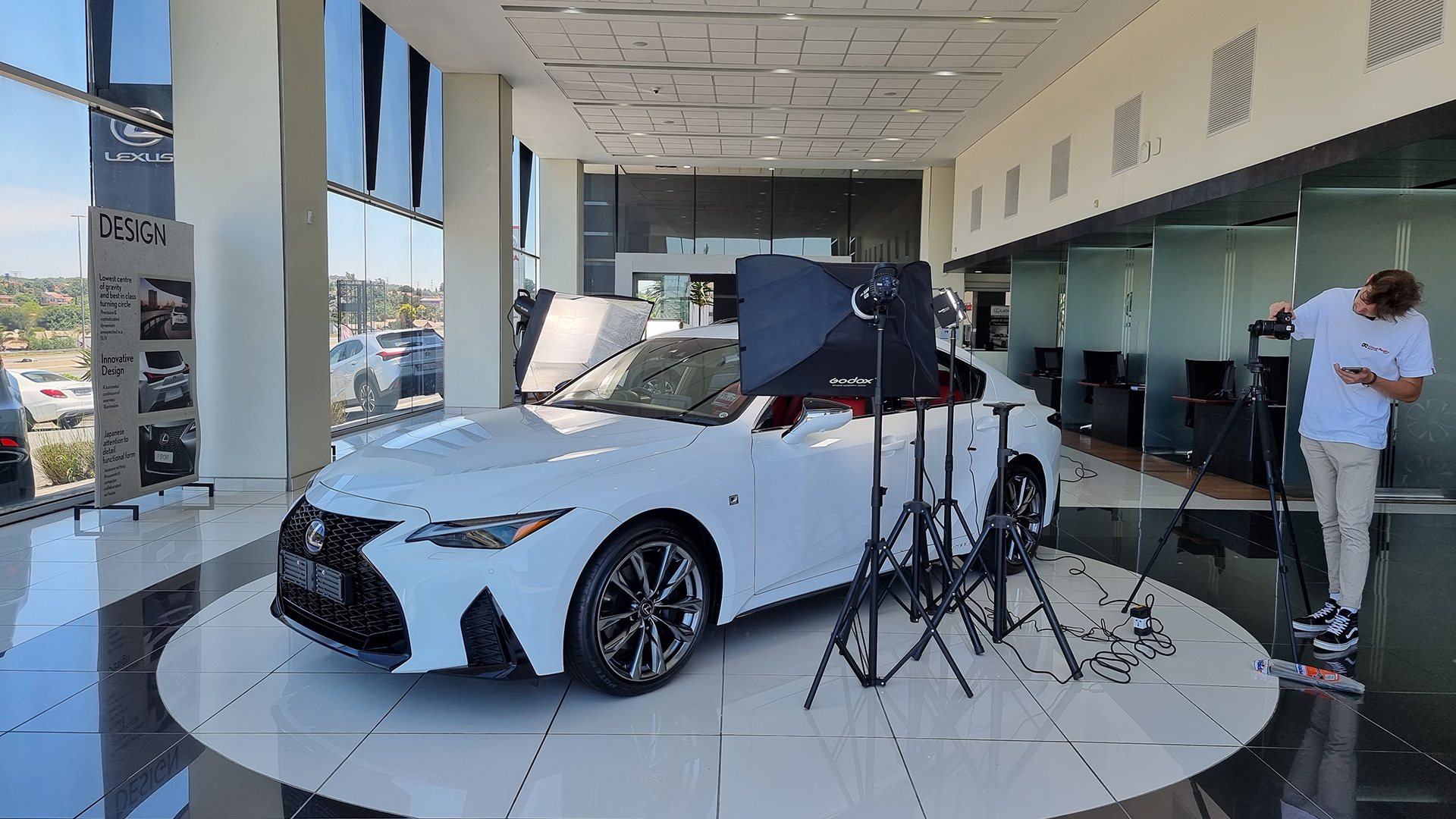 White luxury car displayed in a showroom with photography setup