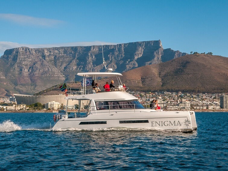Luxury catamaran ENIGMA sailing with Table Mountain in the background.