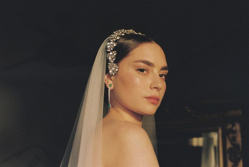 Bride with veil and jewelry looking thoughtfully at the camera