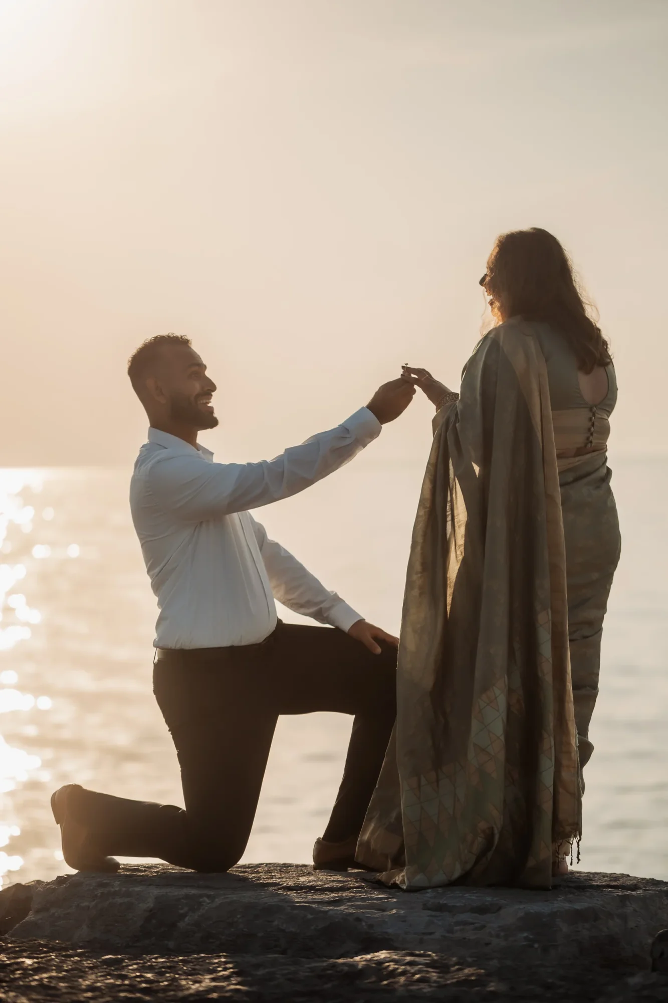 Couple engaged on a beach at sunset