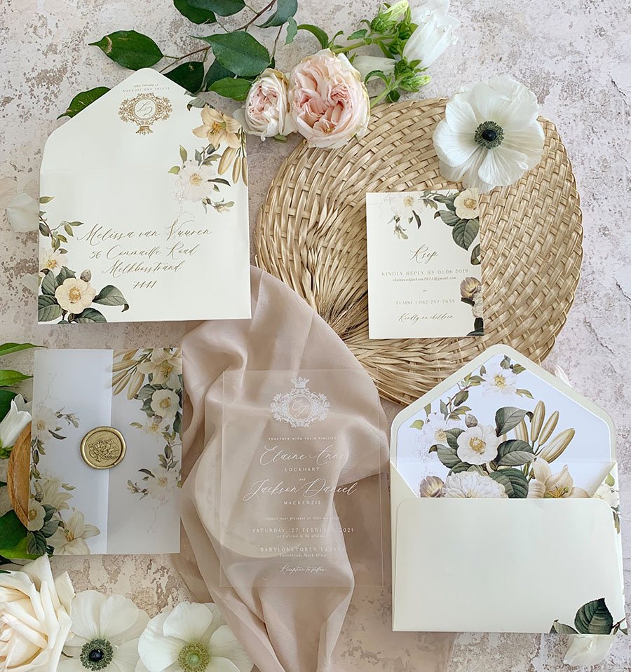 Floral wedding invitation suite with envelopes and details.