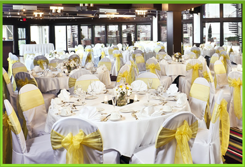 Round tables with white tablecloths and yellow chair sashes
