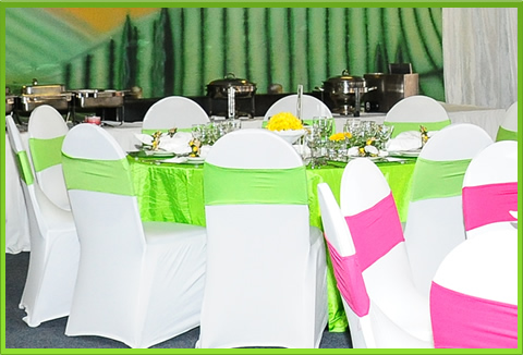 Table with white chairs and colorful sashes
