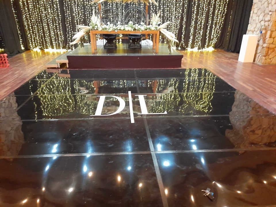 Custom black dance floor featuring logo D/L with twinkling lights backdrop.