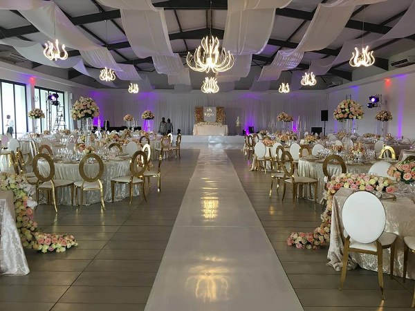Indoor event setup with white flooring and floral decor