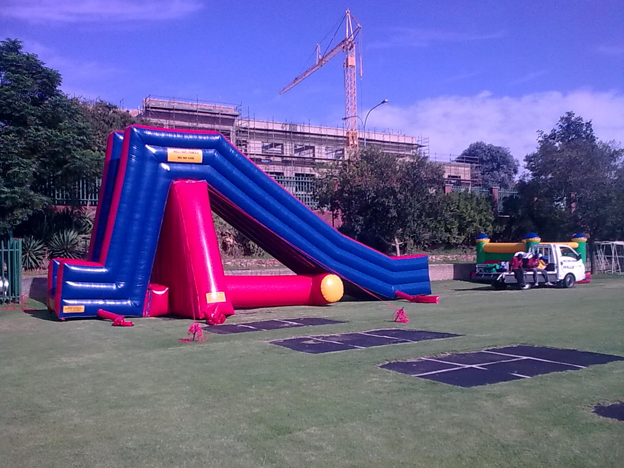 Inflatable water castle being set up on a green field