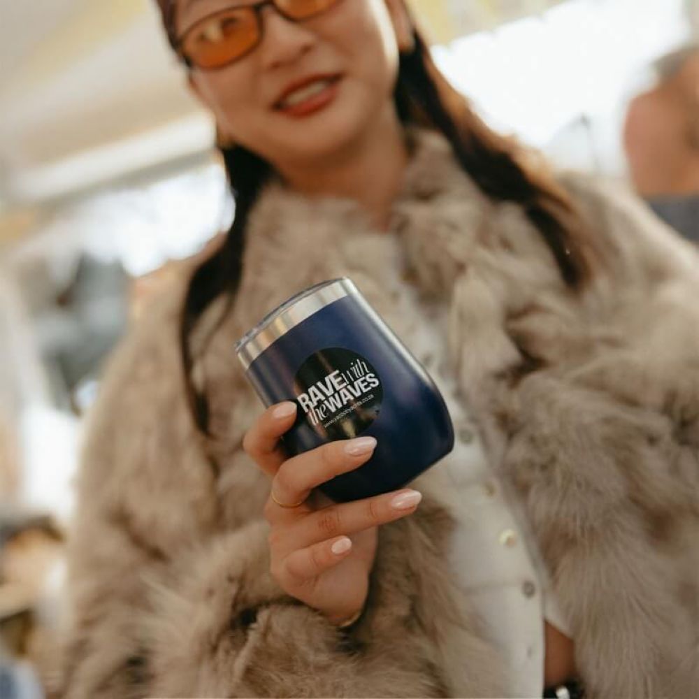 Guest holding a branded insulated drink tumbler