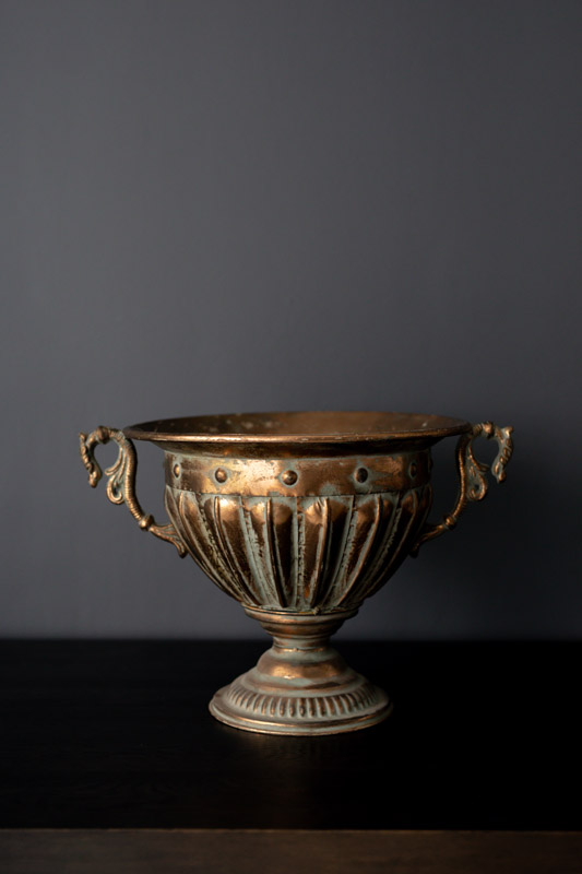Rustic floral centerpiece in bronze on a dark background